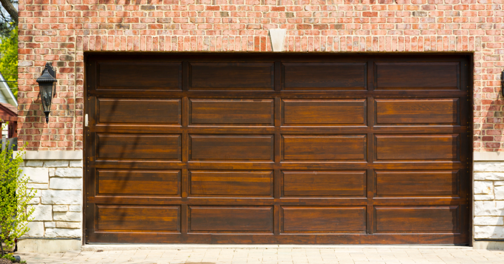 Dark wood garage door in brick frame.